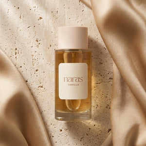 Nafas by Noor Vanilla Extrait de Parfum 100ml bottle resting on travertine stone with champagne silk