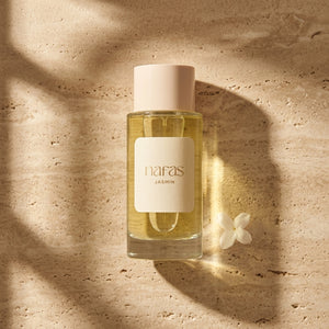 Nafas by Noor Jasmin Extrait de Parfum 100ml bottle on sunlit travertine stone beside a single jasmine flower